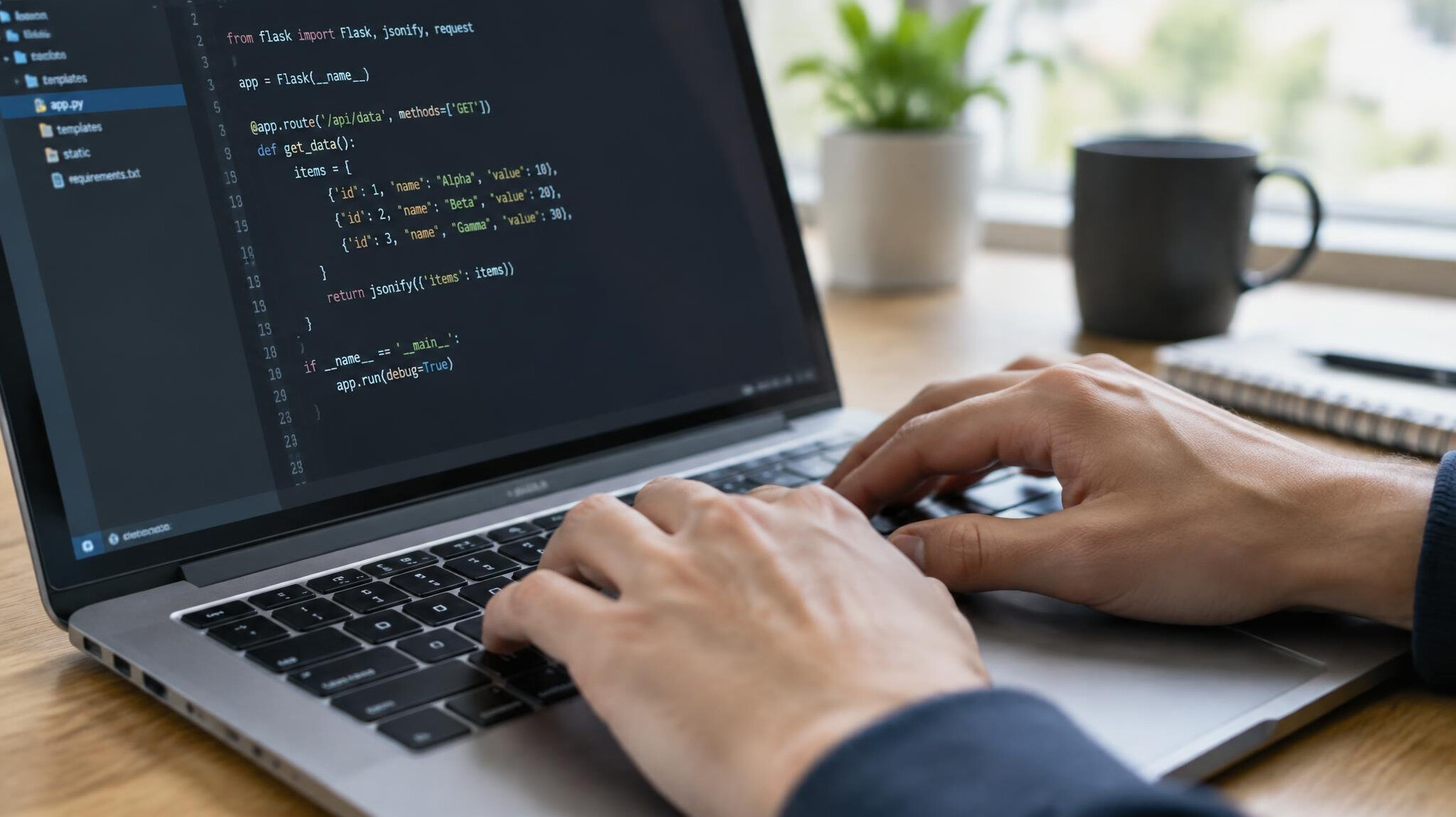 Hands typing code on a laptop